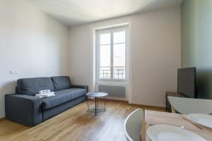 een woonkamer met een bank en een tafel bij Hamac Suites - Monplaisir fully equipped studio-2p in Lyon