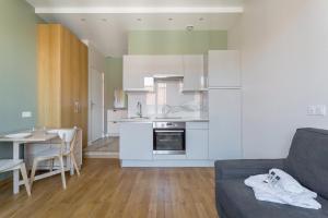 een keuken met witte kasten en een tafel en een bank bij Hamac Suites - Monplaisir fully equipped studio-2p in Lyon