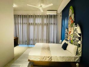 a bedroom with a large bed with a large window at The Kheak in Weligama