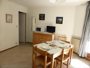 a dining room with a table with chairs and a microwave at Résidence Borgia - 2 Pièces pour 4 Personnes 59 in Les Contamines-Montjoie