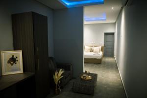 een woonkamer met een bed en een blauw plafond bij The Shelter Abidjan in Abidjan +37 foto's