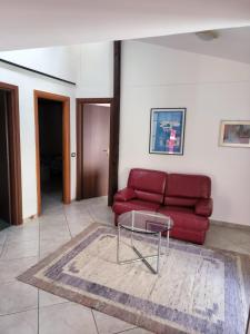 uma sala de estar com um sofá vermelho e uma mesa de vidro em B&B MoMa RG Bojano em Boiano