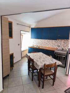 uma cozinha com armários azuis e uma mesa e cadeiras em B&B MoMa RG Bojano em Boiano