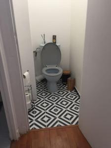 a bathroom with a toilet and a black and white tile floor at Cosy large appartement 20 minutes downtown Paris in Villejuif