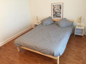a bed with two pillows on it in a room at Cosy large appartement 20 minutes downtown Paris in Villejuif
