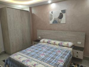 a small bedroom with a bed and a picture on the wall at المعمورة الشاطئ بالاسكندرية شارع سيف وانلي in Alexandria