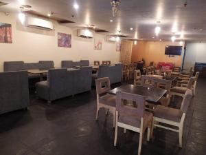 a restaurant with tables and chairs and a tv at The Road View Grand Hotel & Multi Cuisine Restaurant- 18 Percentage Off On Food Order- An Svm Brand in Hyderabad