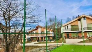 a group of green poles in a yard in front of a building at Ski Dreams Cottage in Bakuriani *4 Bedroom in Bakuriani