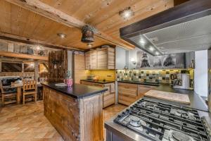 a kitchen with wooden cabinets and a stove top oven at Chalet Colettine - 7 Pièces pour 12 Personnes 09 in Tignes
