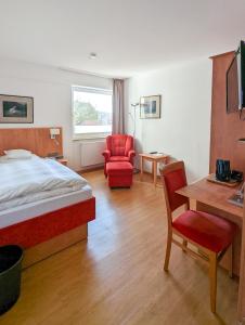 a hotel room with a bed and a desk and chair at Hotel Flörke in Langeoog