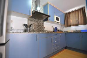 cocina con armarios azules y suelo de madera en RNET - Blau Marina, en Roses