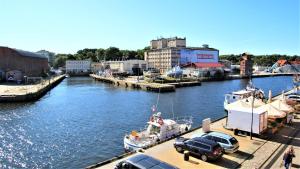 a marina with cars and a boat in a river at Grand Royal Baltic Ustka - luksusowy Apartament 150 metrów od plaży, port, zielony taras, bezpłatny parking, top lokalizacja w centrum Ustki in Ustka