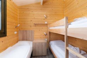 two bunk beds in a cabin with wooden walls at Feriendorf La Mora in Calvi