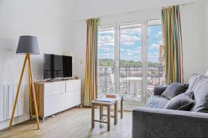 a living room with a couch and a large window at Résidence Port Guillaume - maeva Home - 3 Pièces 6 Personnes Sélection MAE-2368 in Dives-sur-Mer