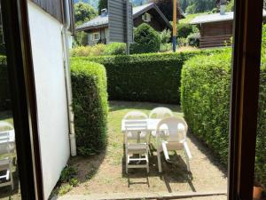 萊蘇什的住宿－Résidence Le Prarion 2 - 2 Pièces pour 6 Personnes 13，坐在庭院里的一组白色椅子