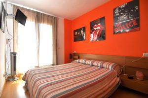 1 dormitorio con paredes de color naranja y 1 cama. en RNET - Blau Marina, en Roses 20 fotos más