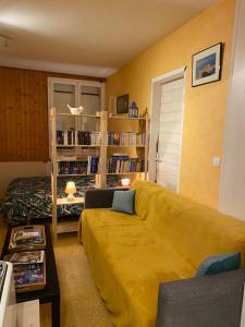 エグファイユ・ドニにあるmaisonnetteのリビングルーム(黄色のソファ、本棚付)