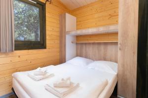 a bedroom with a bed in a wooden cabin at Feriendorf La Mora in Calvi