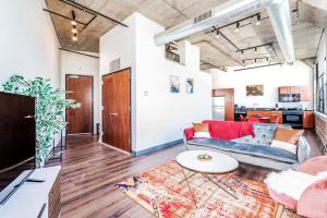 een woonkamer met een bank en een tafel bij TWO Stunning Industrial Lofts by CozySuites in Saint Louis