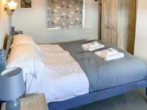 a bedroom with a bed with towels on it at High View in Saint Breward