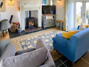 a living room with a blue couch and a fireplace at High View in Saint Breward