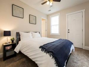 um quarto com uma cama grande e uma ventoinha de tecto em Spacious 3BR House with Backyard in NULU CozySuites em Louisville
