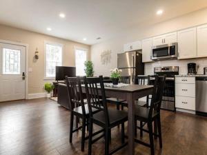 a kitchen with a table and chairs in a room at Spacious 3BR House with Backyard in NULU CozySuites in Louisville