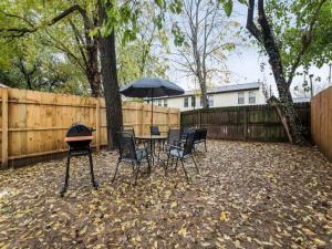 a patio with a table and chairs and an umbrella at Spacious 3BR House with Backyard in NULU CozySuites in Louisville