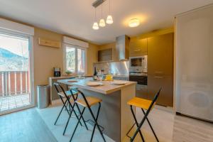 een keuken met een eiland met barkrukken bij Cristal Des Houches - Happy Rentals in Les Houches