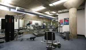 a gym with several treadmills and machines in it at 2BR Architect's STUNNING loft by CozySuites in Saint Louis