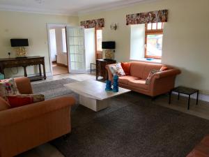 een woonkamer met 2 banken en een salontafel bij Beautiful 2 Bedroom Barn in Towcester Northants in Litchborough