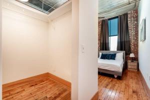 a bedroom with a bed and a brick wall at Stunning 1BR Adler Loft by CozySuites in Saint Louis