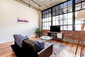 a living room with a couch and a tv at Sleeps 3 Stunning 1BR by CozySuites in Saint Louis
