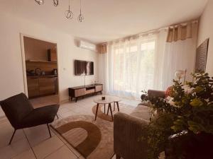 a living room with a couch and a table at ELSA / Appartement P3 + Parking in Nîmes