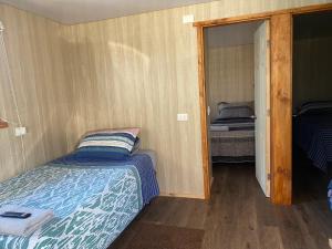 ein kleines Schlafzimmer mit einem Bett und einem Spiegel in der Unterkunft Alojamiento Rústico Belloto 4 in Quilpué