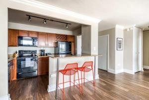 an empty kitchen with two red chairs at a counter at CozySuites 800 Tower 1BR w sky pool, gym! 26 in Louisville