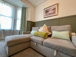 un sofá con almohadas en una habitación en HNFC Stays - Spacious house w/ all essentials - 3b, en Newcastle
