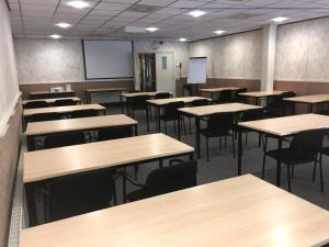 an empty classroom with tables and chairs at Hotel Frans op den Bult in Deurningen