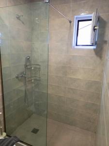 a bathroom with a shower with a glass door at KaVros Cozy Apartment in Kavros