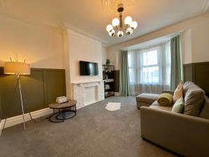 sala de estar con sofá y chimenea en HNFC Stays - Spacious house w/ all essentials - 3b, en Newcastle