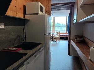 cocina con nevera blanca y mesa en Résidence Cascade - Studio pour 4 Personnes 64, en Arc 1600