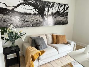 una sala de estar con un sofá blanco y una pintura en la pared en Boutique-Aalborg-Free parking - Citycenter en Aalborg