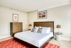 a bedroom with a large white bed and a red rug at CozySuites 800 Tower 1BR w sky pool, gym! 24 in Louisville