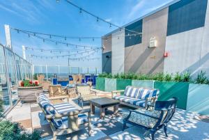 a patio with chairs and tables on top of a building at CozySuites 800 Tower 1BR w sky pool, gym! 24 in Louisville