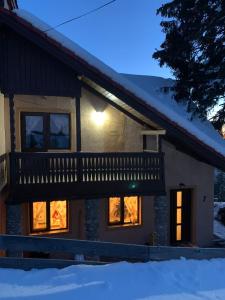 a house with a deck in the snow at Casa Iarina Rânca in Ranca