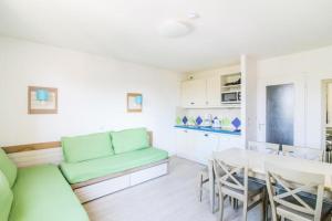 a living room with a green couch and a table at Résidence Saint-Raphaël Valescure - maeva Home - 2 Pièces 6 Personnes Sélection MAE-4876 in Valescure