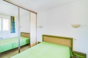 a bedroom with a bed and a mirror at Résidence Saint-Raphaël Valescure - maeva Home - 2 Pièces 6 Personnes Sélection MAE-4876 in Valescure