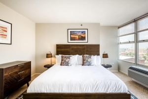 a bedroom with a large bed and two windows at CozySuites 800 Tower 1BR w sky pool, gym! 14 in Louisville