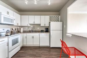 a kitchen with a white refrigerator and a red chair at CozySuites 800 Tower 1BR w sky pool, gym! 12 in Louisville