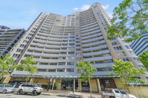 a tall building with cars parked in front of it at Hotel styling entire one bedroom in Sydney